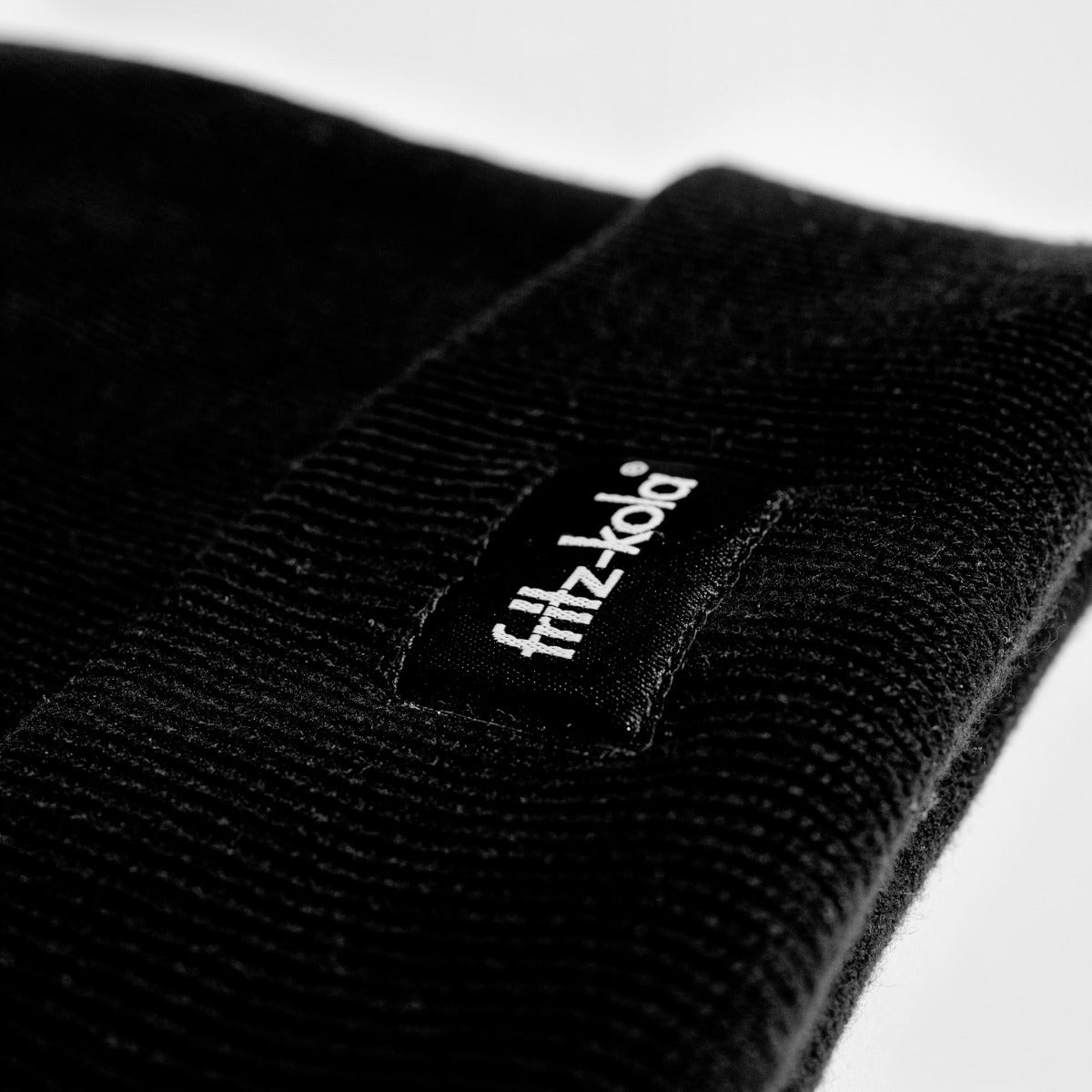 schwarze beanie mit fritz-kola patch auf der stirn