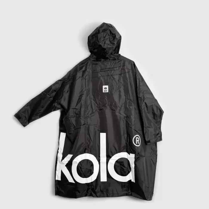 Schwarzer Regenponcho mit Kapuze flach ausgebreitet. Großer weißer "kola" Schriftzug auf der Rückseite