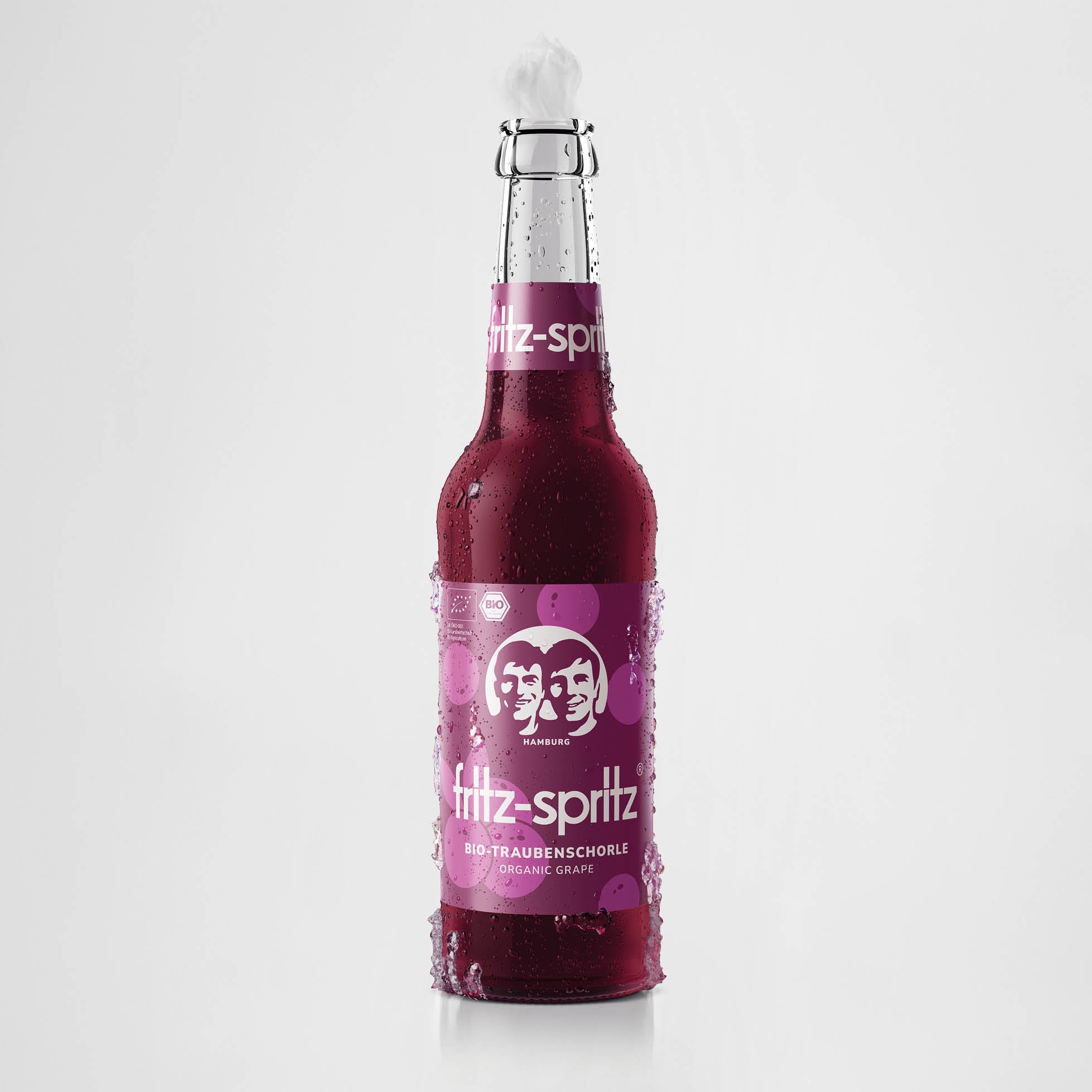 Eine Flasche fritz-spritz bio-traubenschorle. Die Flasche ist mit Kondenswasser bedeckt und steht vor einem hellen Hintergrund.