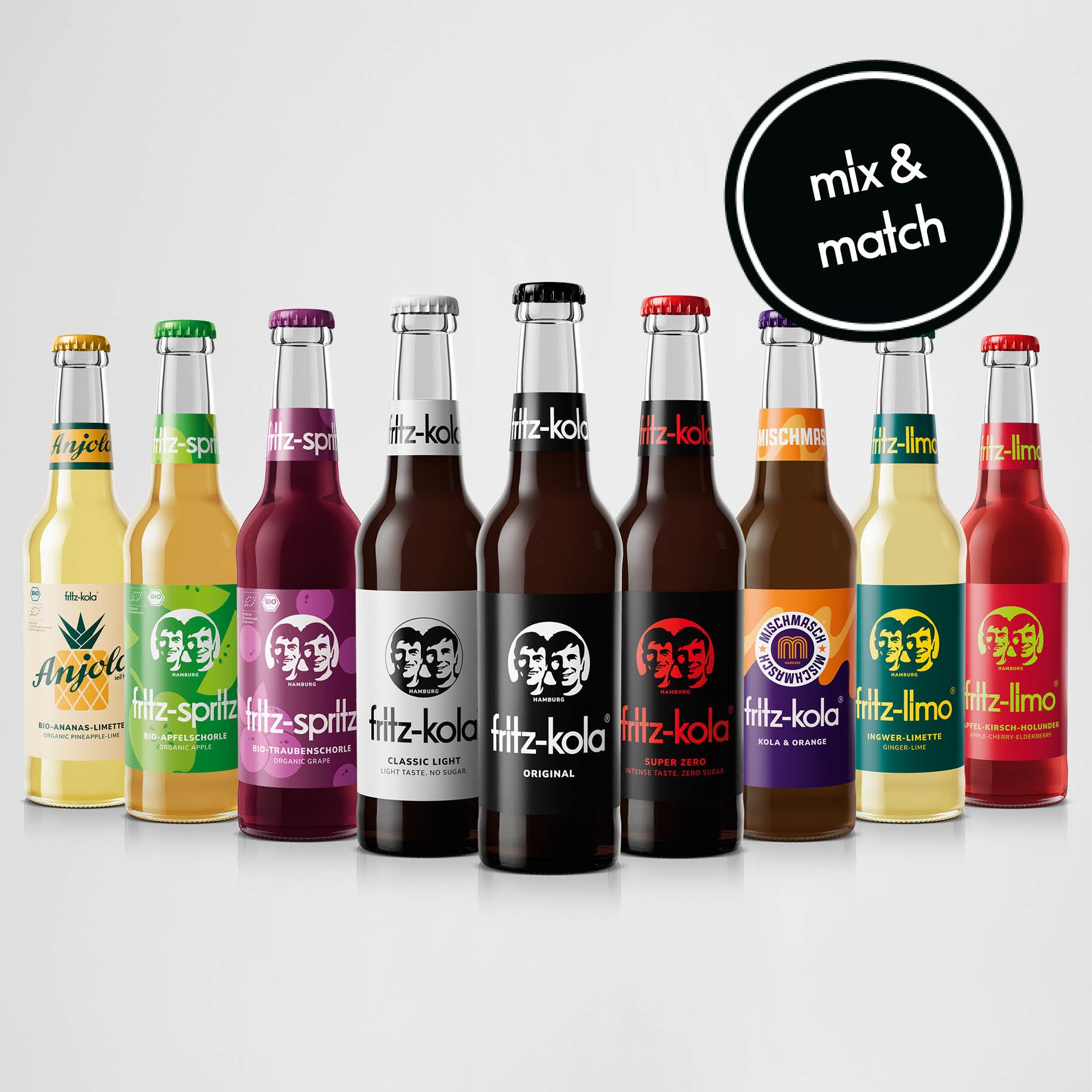 Produktaufnahme von neun verschiedenen fritz-kola Getränken in Glasflaschen, aufgereiht vor hellem Hintergrund. Von links nach rechts: Anjola, fritz-spritz bio apfelschorle, fritz-spritz bio traubenschorle, fritz-kola classic light, fritz-kola original, fritz-kola super zero, mischmasch kola + orange, fritz-limo ingwer-limette und fritz-limo apfel-kirsch-holunder. Oben rechts ein schwarzer Kreis mit weißer Aufschrift 'mix & match'.